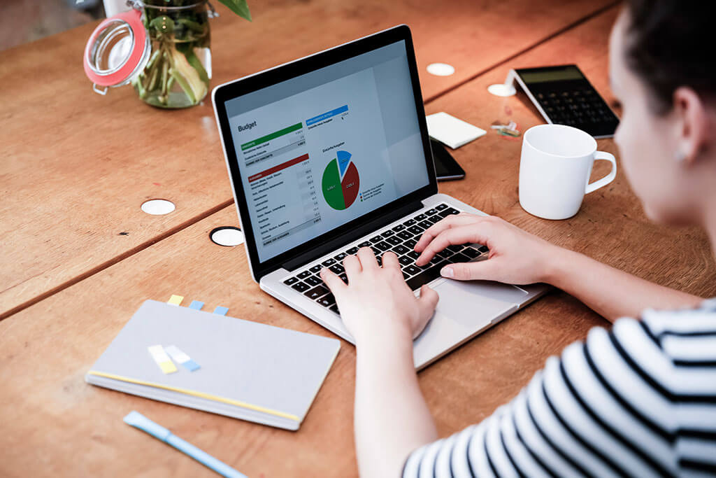 女人在桌子上使用笔记本电脑